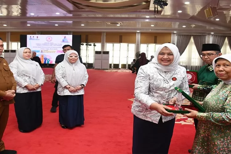 Ketua Yayasan Kanker indonesia (YKI) Sumut Nawal Lubis menyerahkan plakat YKI Sosialisasi Kondisi Kanker di Sumut diantaranya kepada Ketua PDM Kota Medan Maulana Siregar (Realitasonline.id/mis)