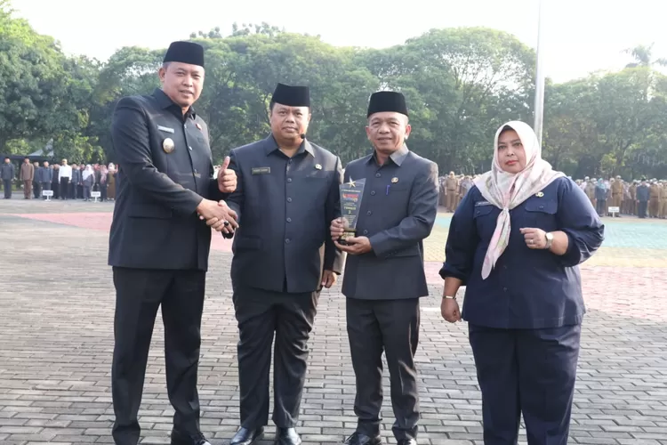 Plt Wali Kota Bekasi Tri Adhianto memberikan penghargaan secara simbolis kepada Kadis Perdagangan dan Perindustrian yang berprestasi usai apel pagi di Plaza Pemkot Bekasi, Senin (24/7/2023). (FOTO: Humas Setda Kota Bekasi)