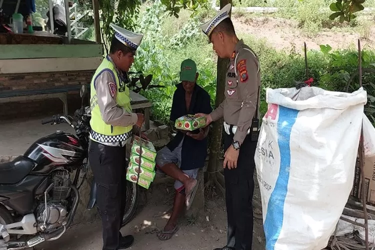 Kasat Lantas Polres Batubara AKP HW Siahaan SH memberikan bantuan Nasi kotak kepada pedagang yang melintasi area patroli  (Realitasonline/H.Guntur Sinaga)