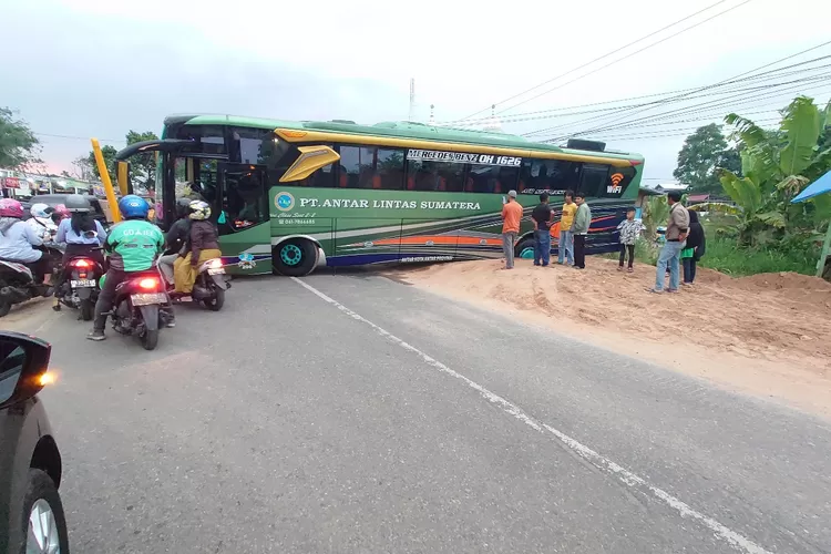 Sebuah bus terperosok di By Pass Bukittinggi mengakibatkan arus lalu lintas tersendat (Harianhaluan.com/Vesco)
