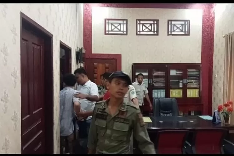 Dikawal personil Satpol PP Paluta, beberapa mahasiswa menggeledah ruang Kadis  PU-TR Paluta saat melakukan aksi demo (Realitasonline.id/ASR)
