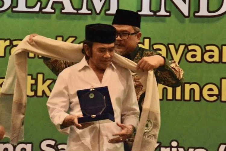 Ketua MUI Bidang Seni Budaya dan Perdaban Islam Dr. KH. Jeje Zaenudin mengenakan selendang MUI kepada Raja Dangdut KH. Rhoma Irama - Foto: Tangkap layar mui.or.id