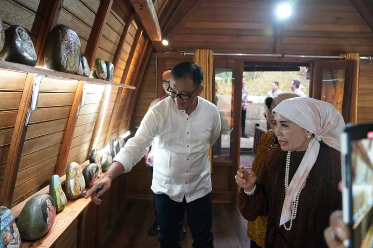 Plt Bupati Bogor Iwan Setiawan didampingi Halimah Munawir saat berkeliling di galeri lukisan batu Lady Diana di Rumah Budaya HMA, Megamendung, Kabupaten Bogor, Kamis 3 Agustus 2023. (Arifin)