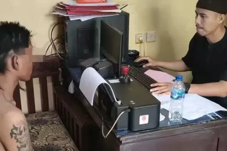 Personel Polsek Citamiang, Sukabumi Kota menginterogasi pria terduga pelaku pengeroyokan dan penganiayaan terhadap perempuan di Cikondang, Sukabumi. (Radar Sukabumi)