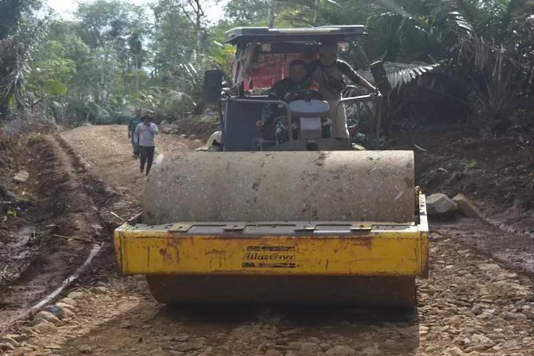 Alat berat jenis loader sedang bekerja melakukan pengerasan badan jalan baru, melalui program TMMD 117 Kodim 0212/Tapsel di Desa Sitaratoit Angkola Barat Tapsel  (Realitasonline.id/Riswandy)
