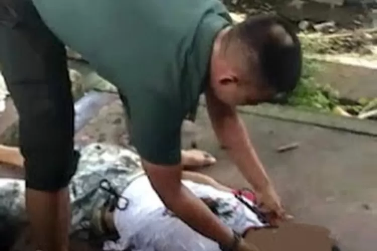 Kapten Inf Rhadi Yanuar evakuasi mayat pemulung dari dalam parit. (Instagram Kodam I Bukit Barisan.)