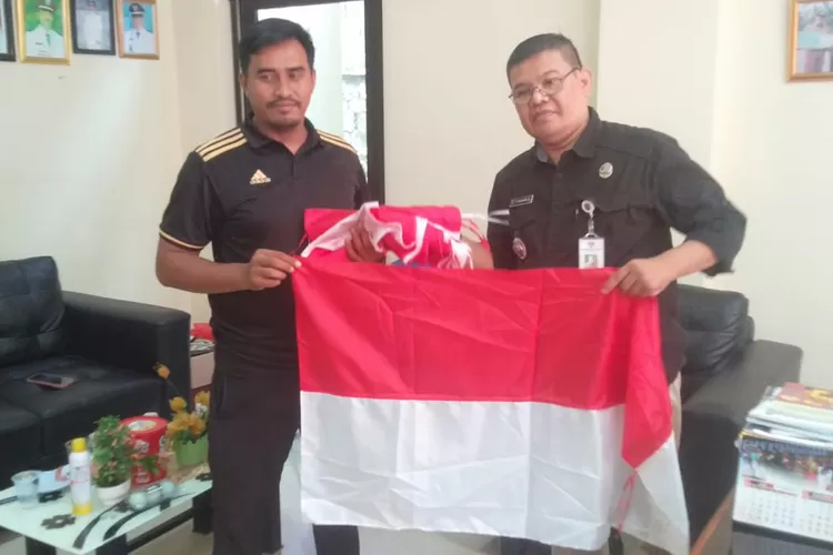 SERAH TERIMA : Lurah Jatijajar, Mujahidin memberikan sejumlah bendera kepada pengurus RW8 Kelurahan Jatijajar untuk menyemarakan HUT RI ke-78.  (ANDIKA EKA/RADAR DEPOK)