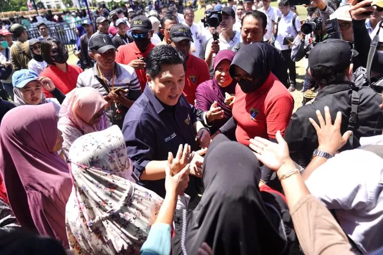Menteri BUMN Erick Thohir (tengah) menyapa warga saat gelaran pasar murah di Surabaya, Jawa Timur, Minggu (13/8/2023).  (ANTARA/Dhemas Reviyanto)