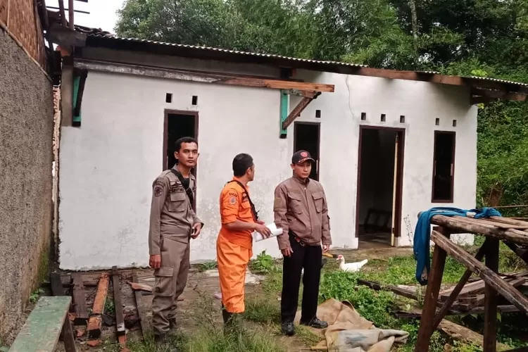 RUMAH RUSAK: Sekdes Sukadamai, Devi, bersama Satpol PP Kecamatan Dramaga sedang mendata rumah warga yang rusak akibat angin kencang.