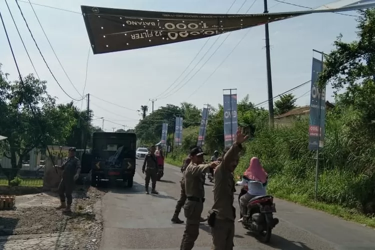 TERTIBKAN: Anggota Satpol PP Kecamatan Ciampea saat menertibkan spanduk liar.