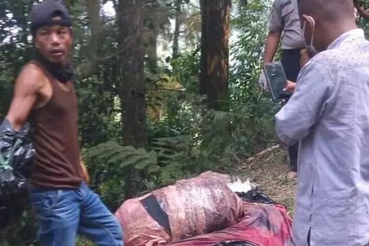 EVAKUASI: Mayat tanpa identitas yang dibuang dalam koper tengah dievakuasi petugas dibantu warga sekitar