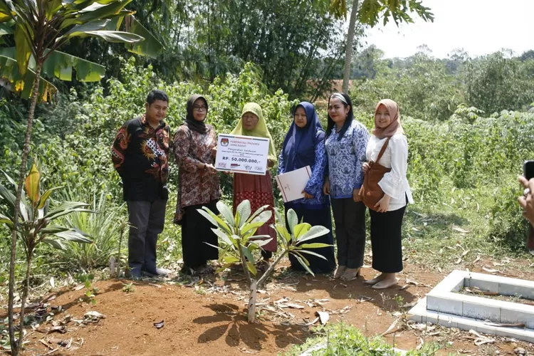 ZIARAH:Ketua KPU Kabu-paten Bogor, Ummi Wahyuni, bersama Komisioner Herry Setiawan dan jaja-rannya saat ziarah dan menyerahkan penghargaan kepa-da petugas pemilu yang meninggal, kemarin.