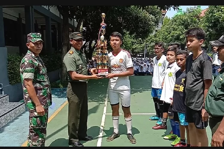JUARA:Danramil 06 Ta-nahsareal meny-erahkan piala ke-pada pemenang futsal di SMPN 5 Tanahsareal.
