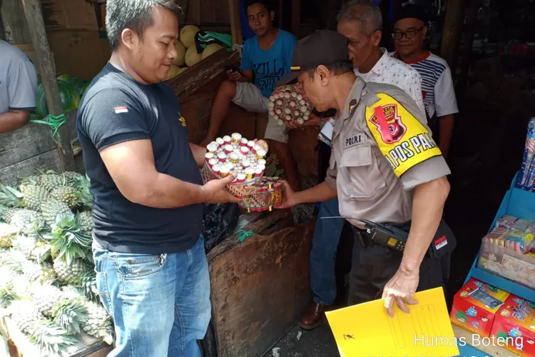 RAZIA: Kapolsek Bogor Tengah Kompol Syaefudin Gayo mengamankan petasan dari pedagang di Pasar Anyar.