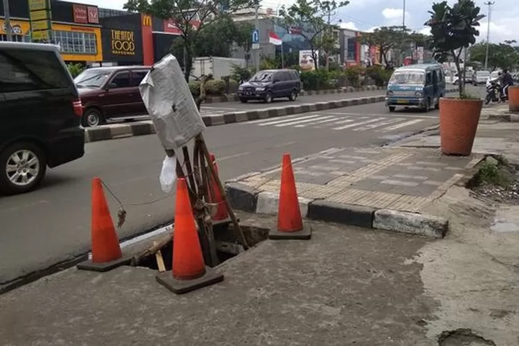 OLAH TKP: Petugas kepolisian mendatangi lokasi hilangnya penutup gorong-gorong di Jalan Margonda Raya, Depok, kemarin.EVAKUASI: Buaya sepanjang 1,85 meter dengan kondisi terikat dievakuasi warga dari dalam saluran air di Jaka Sampurna, kemarin.