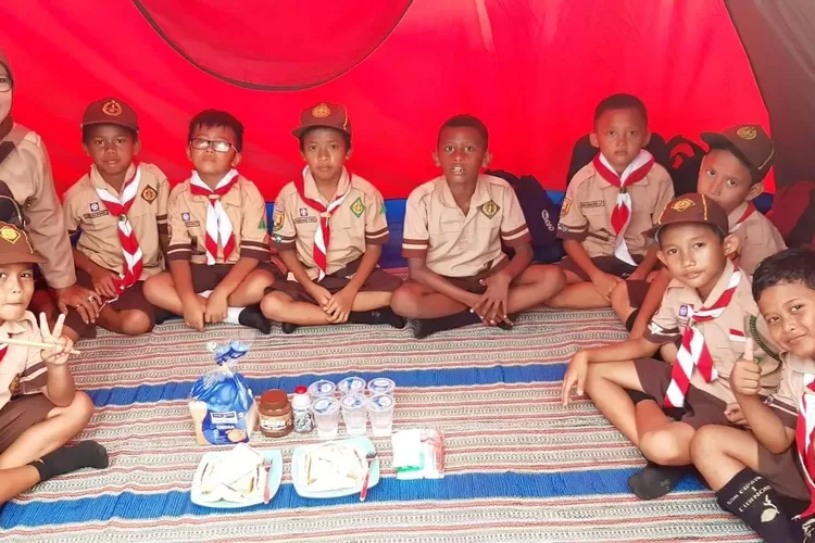 DAMPINGI: Seorang guru, Anjasmarawati, saat mendampingi anak didiknya dalam kemah saat persami dan persari. Kegiatan ini untuk melatih kemandirian dan menumbuhkan tolong-menolong.