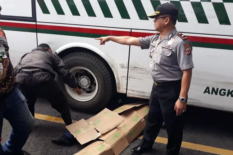 TRAGIS: Kapolsek Cibungbulang bersama anggotanya sedang mengevakuasi korban terlindas bus di Jalan Cibungbulang.
