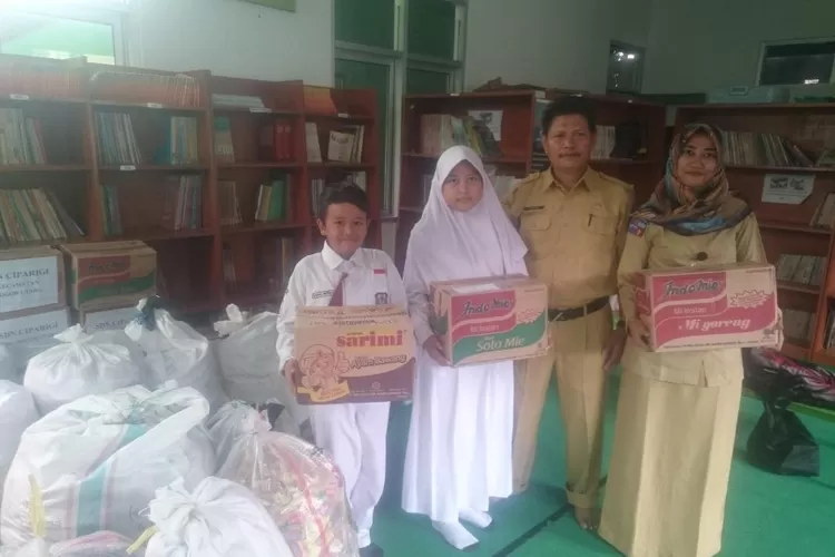 BANTU: Ketua Kwaran Pramuka Kecamatan Bogor Utara dan Kepala SDN Bantarjati 9, Enjum, foto bersama guru dan muridnya sebelum menyerahkan bantuan ke Kwarcab Kota Bogor.