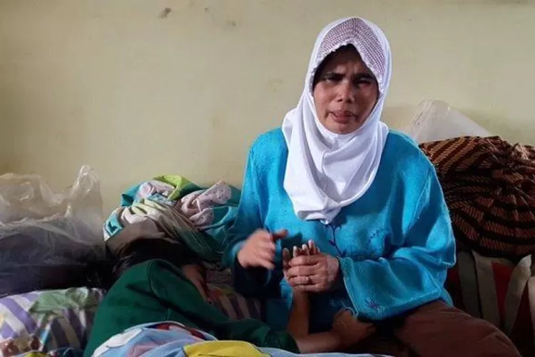 NGUNGSI: Armanah mengungsi bersama anaknya di musala yang jauh dari kediamannya.