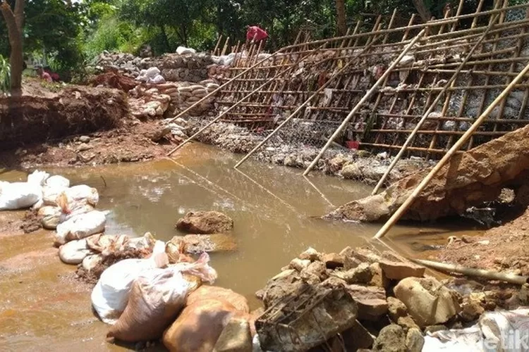 GOTONG- ROYONG: Warga Puri Citayam Permai 2, Kecamatan Bojonggede, bekerja sama memperbaiki tanggul yang jebol, kemarin