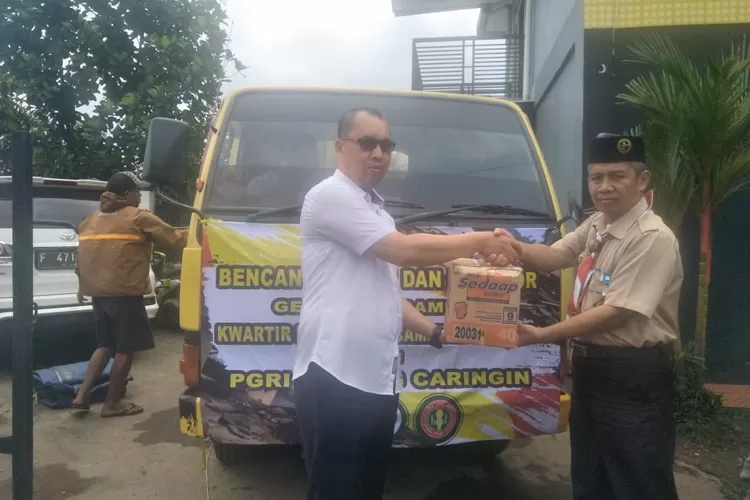 BANTU: Ketua Pramuka Kwaran Caringin, Endang, menyerahkan bantuan untuk warga Nanggung yang terdampak bencana.