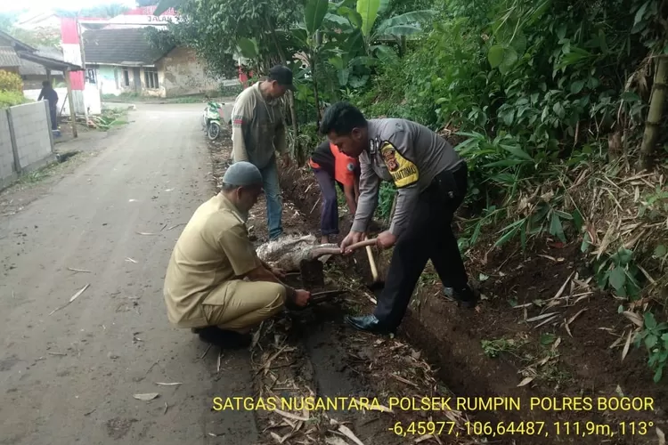 KOMPAK: Bhabinkamtibmas bersama kades Kampung Sawah gotong-royong membersihkan saluran air di Kampung Panoongan.