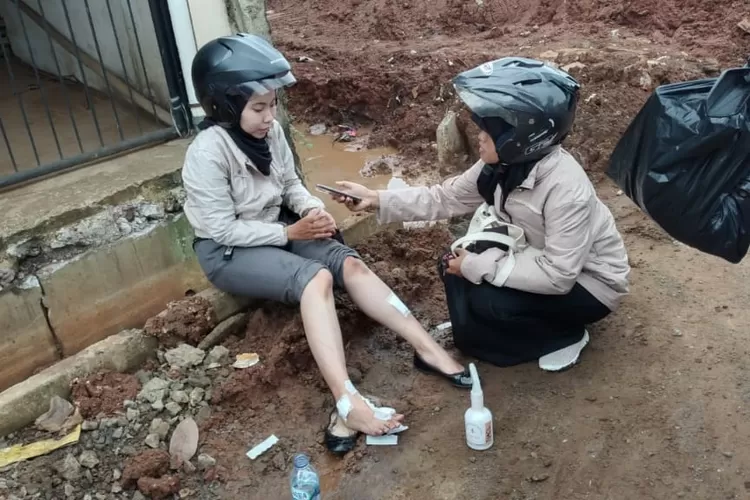 SYOK: Salah seorang pengendara motor terkulai usai terlibat kecelakaan beruntun di lokasi proyek Tol BORR.