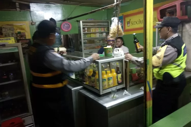 OPERASI: Petugas Polsek Parung mengamankan berbagai jenis miras di sebuah warung di Parung.