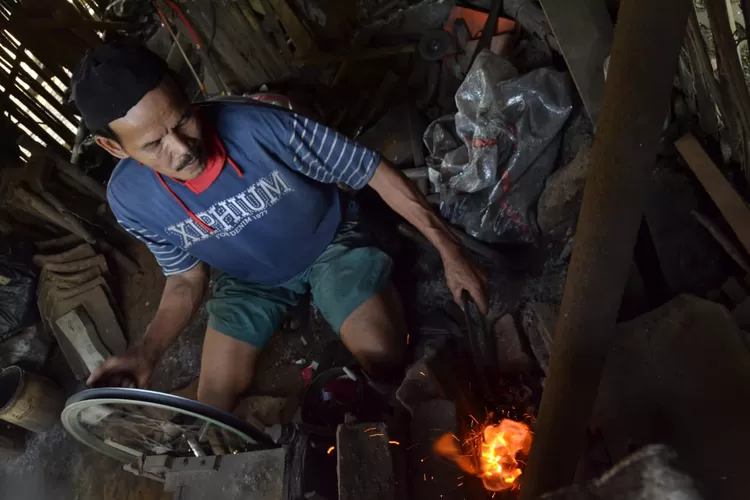 BAKAR-Seorang pandai besi saat membakar bilah golok/Hendi Radar Bogor