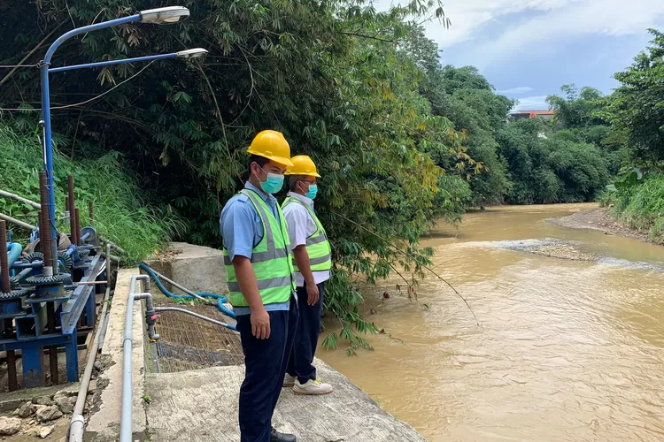 sejumlah petugas operator perumda air minum tirta kahuripan kabupaten bogor memantau debit air sungai ciliwung di intake instalasi pengolahan air cibinong