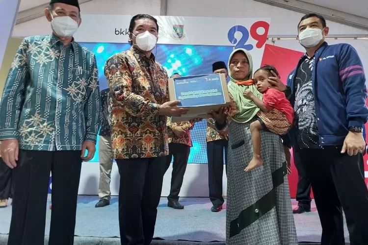 Head of Sales XL Axiata Area Banten Outer, Tom Dedi (paling kanan) bersama Pj. Gubernur Banten, Al Muktabar (kedua kiri) didampingi Ketua Baznas Provinsi Banten, Sibli Sarjaya (paling kiri) menyerahkan paket makanan sehat kepada perwakilan anggota keluarga binaan Perwakilan BKKBN Provinsi Banten pada Acara Peringatan Hari Keluarga Nasional Ke-29 Tingkat Provinsi Banten Tahun 2022 di Kota Cilegon, Selasa (12/7). XL Axiata mendukung Perwakilan Badan Kependudukan dan Keluarga Berencana Nasional (Perwakilan BKKBN) Provinsi Banten dalam program “Gerakan Bapak Asuh Anak Stunting” dengan memberikan ratusan paket makanan sehat.