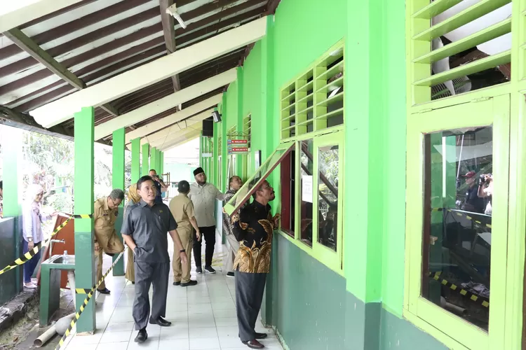  Anggota DPRD Jatirin mengintip ruang kelas yang rusak melalui jendela