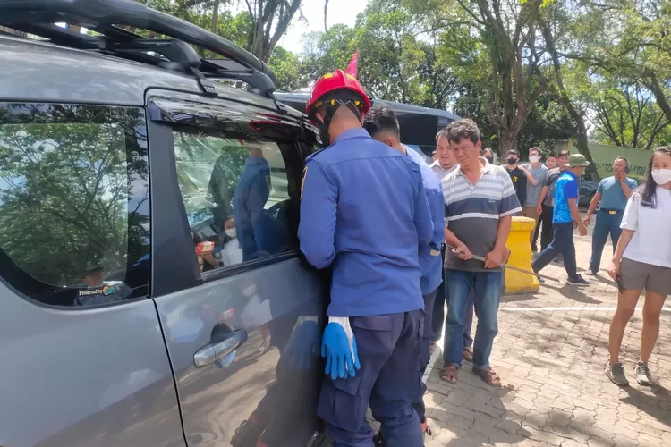 Petugas Damkar Kabupaten Bogor mengevakuasi balita yang terkunci dalam mobil di Rest Area Sentul, Rabu 11 Januari 2023. (IST)