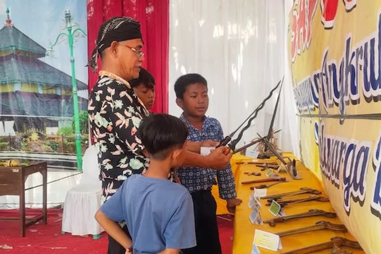 Sejumlah siswa SDN Kuwu 1 Kecamatan Dempet melihat keris dan benda cagar budaya (suaramerdeka.com / dok)