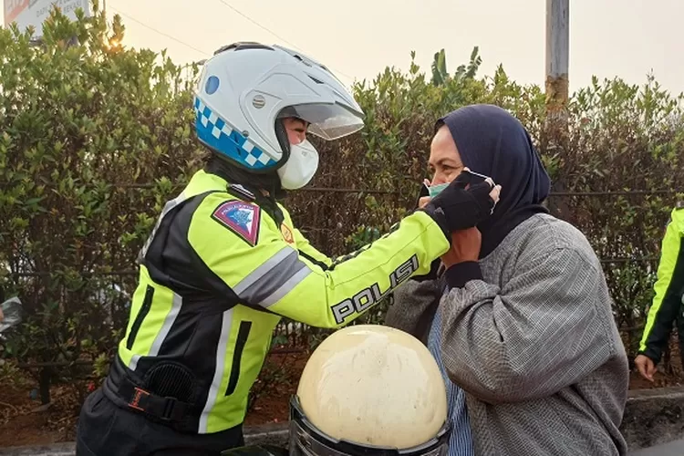 Aksi simpati polwan Satlantas Polres Metro Depok bagikan masker untuk pengendara (HarianHaluan.com)