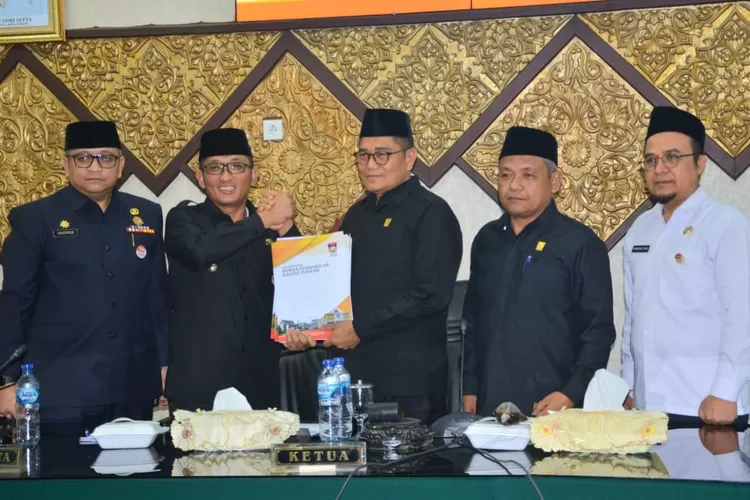  Wako Hendri Septa menerima pengesahan Perda dari pimpinan DPRD Kota Padang. (Prokopim)  