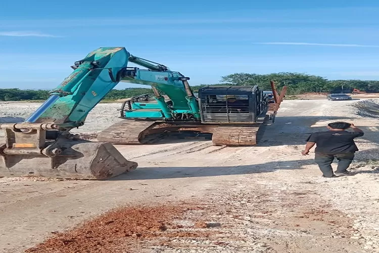  escavator sedang melakukan pengerukan tanah untuk diangkut ke dump truk jenis Fuso (Realitasonline.id/AA)
