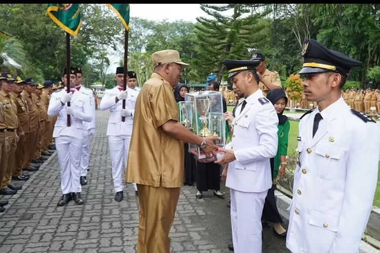 Plt Bupati Langkat H.Syah Afandin SH menyerahkan Tunggul Kecamatan dan Kelurahan Terbaik Tahun 2023 Tingkat Kabupaten Langkat, pada Apel Gabungan (Realitasonline.id/AA)