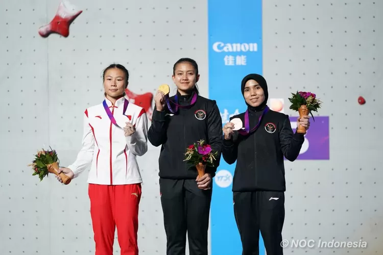 Desak Made Rita Kusuma Dewi memperlihatkan medali emas saat berpose di podium panjat tebing Asian Games 2022 di Hangzhou, China, Selasa (3/10/2023).  (NOC Indonesia / M Rifqy Priadiansyah)