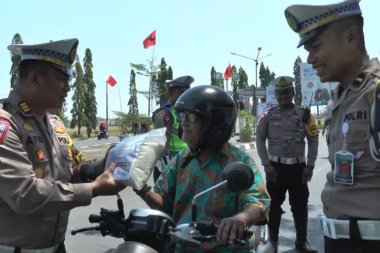 Kasat Lantas Polres Kendal membagikan beras kepada pengguna jalan yang tertib berlalu lintas dalam operasi zebra candi 2023. (AyoSemarang.com: Edi Prayitno kontributor Kendal)