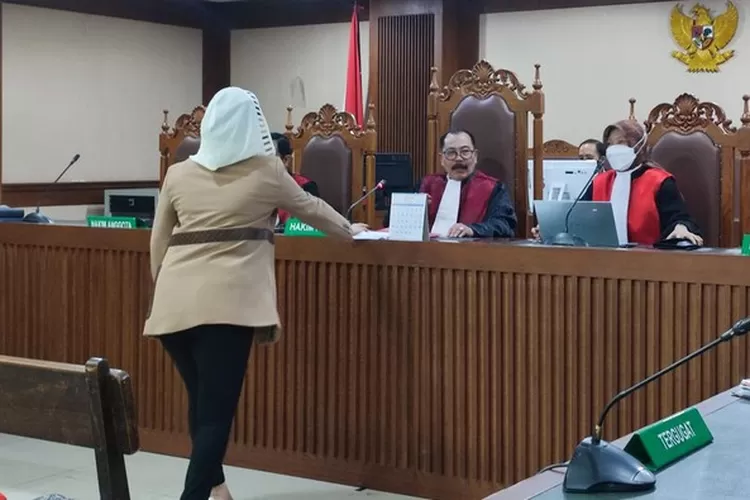 Hasnaeni menyerahkan secarik kertas kepada hakim sebelum pembacaan sidang vonis. (istimewa)