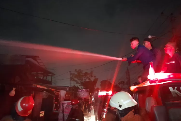 PEMADAMAN : Upaya Dinas Pemadam Kebakaran mengamankan lokasi kejadian di salah satu kios yang terbakar, di Jalan Raya Keadilan RT2/9, Kelurahan Rangkapanjaya Baru, Kecamatan Pancoranmas, Selasa (29/8). (&nbsp;ALDY RAMA/RADAR DEPOK)