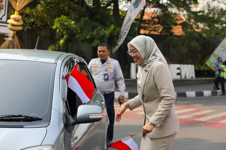 Bupati Purwakarta Anne Ratna Mustika membagikan bendera merah putih kepada pengendara. (DIskominfo Purwakarta)