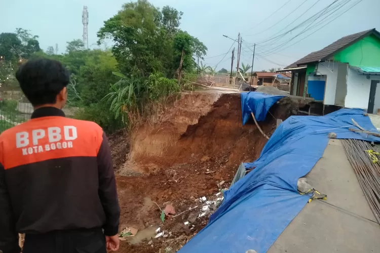Petugas BPBD Kota Bogor mengecek lokasi TPT setinggi 8 meter yang mengalami longsor. Terlihat, kios milik warga roboh imbas kejadian ini. (Dok BPBD Kota Bogor) 