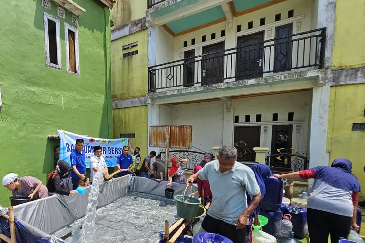 Kades Wates Jaya Rudi Irawan (kanan) didampingi tim AQUA salurkan air bersih di desa Wates Jaya, Kecamatan Cigombong, Kab Bogor.