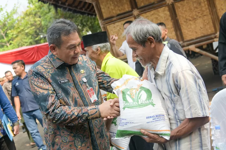 Pj Bupati Purwakarta Benni Irwan memberikan beras kepada warga dalam gerakan pangan murah. (Diskominfo Purwakarta)