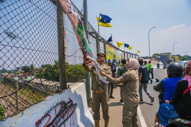 Tim Tangkas Kota Bogor mencopot spanduk parpol di Fly Over Jalan RE Martadinata. (Pemkot Bogor)