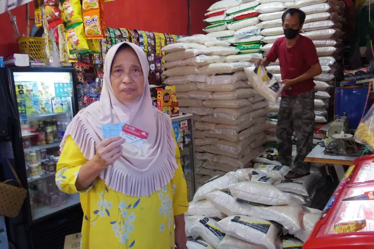 BANSOS : Salah satu warga menunjukan kartu untuk bantuan sembako di Warung Matahari Terbit, Jalan Talas, RT1/13, Kelurahan Beji, Kecamatan Beji, Senin (29/8). ALDY RAMA/RADAR DEPOK