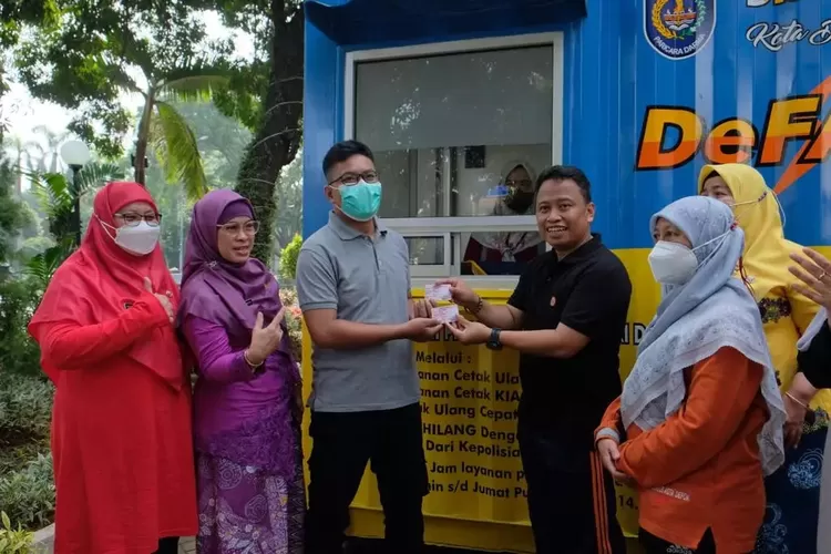 SERAHKAN DATA : Sekda Kota Depok Supian Suri sedang menyerahkan dokumen kependudukan, kepada seorang warga yang mengurus dokumen lewat program De Fast Disdukcapil. Istimewa