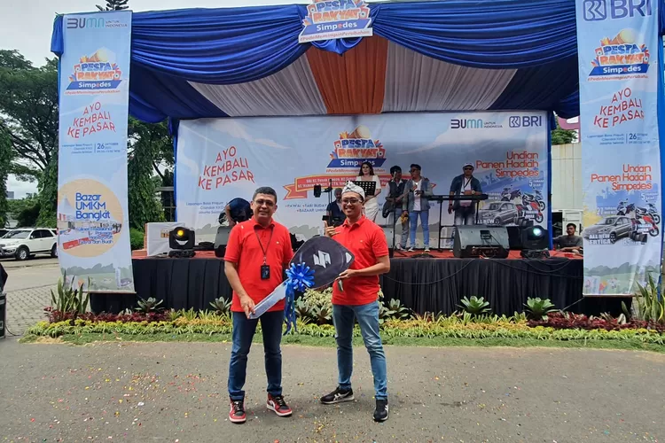 SIMBOLIS : Pinca BRI KC Pasar Minggu, Yoni Ariyanto menyerahkan secara simbolis grandprize satu unit Suzuki Ertiga kepada Kepala Unit BRI Unit Benda Raya, Nuri Deyanda dalam Pesta Rakyat Simpedes 2022 yang diselenggarakan di Balai Prajurit KKO, CIlandak, Jakarta Selatan, Rabu (26/10). RICKY/RADARDEPOK